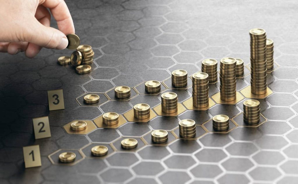The $100,000 TFSA Milestone: The right way to Begin Closing the Hole In the present day hand stacks coins